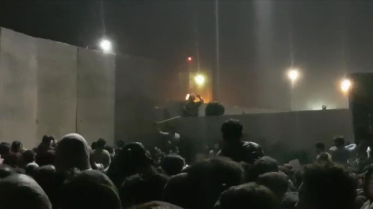 This footage shows crowds gathered at the airport at night as those guarding the airport can be seen firing into the air.