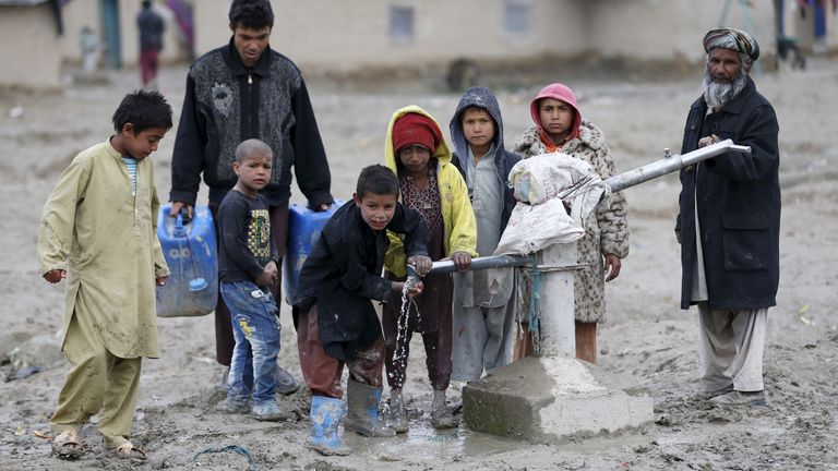 Children drink water from a public water pump on the outskirts of Kabul, Afghanistan March 4, 2016