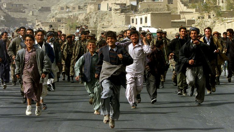 FILE PHOTO: Residents of Kabul celebrate and escort Northern Alliance fighters entering the Afghan capital Kabul, Afghanistan November 13, 2001. REUTERS/Yannis Behrakis/File Photo
