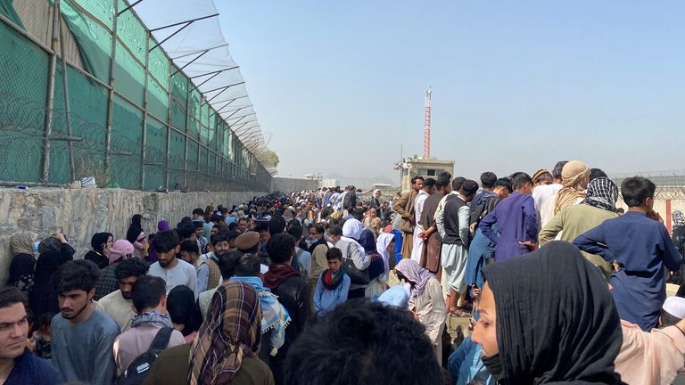Crowds of people gather near the airport in Kabul