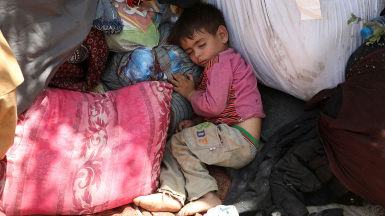 An internally displaced child from northern provinces sleeps in a park  in Kabul