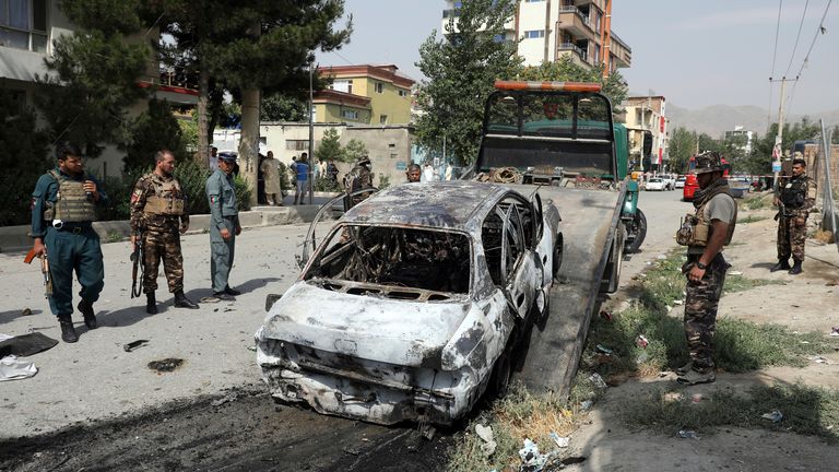Des agents de sécurité afghans inspectent un véhicule endommagé qui transportait et tirait des roquettes, à Kaboul, en Afghanistan, le mardi 20 juillet 2021.