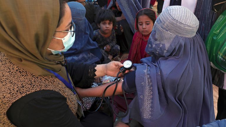 Internally displaced Afghan women from northern provinces, who fled their home due to fighting between the Taliban and Afghan security personnel, receive medical care in a public park in Kabul, Afghanistan, Tuesday, Aug. 10, 2021. (AP Photo/Rahmat Gul)