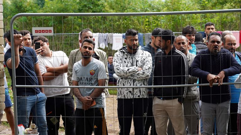FILE PHOTO: Migrants gather near a fence at a temporary detention center in Kazitiskis, Lithuania, August 12, 2021. Picture taken on August 12, 2021. REUTERS/Janis Laizans/File Photo
