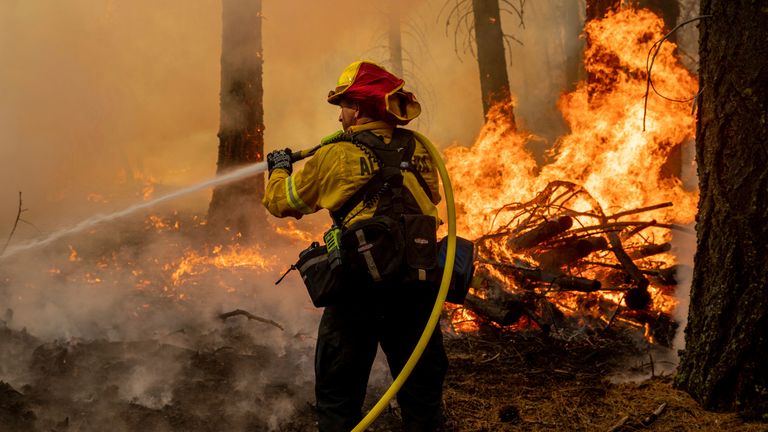A firefighter battles the Dixie Fire in Genesee, California, 21 August. Pic: AP