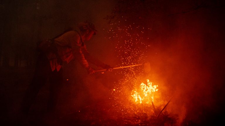 A firefighter battles the Dixie Fire in Genesee, California, 21 August. Pic: AP