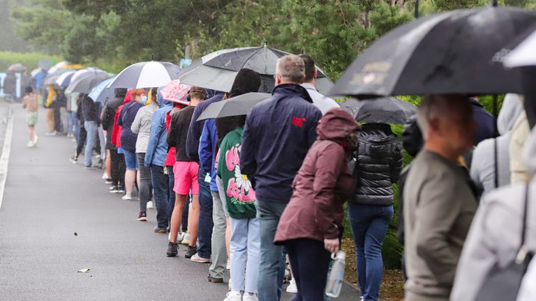 Parents and their children queue in the pouring rain outside the Citywest Covid-19 Vaccination Centre in Dublin as vaccinations of children and teenagers begins across Ireland, with more than 23 percent of those aged 12 to 15 registered to receive the jab. Picture date: Saturday August 14, 2021.


