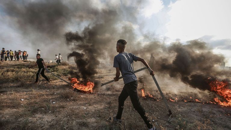 Protesters burn tyres after clashes with Israeli security forces at the border fence with Israel. Pic AP