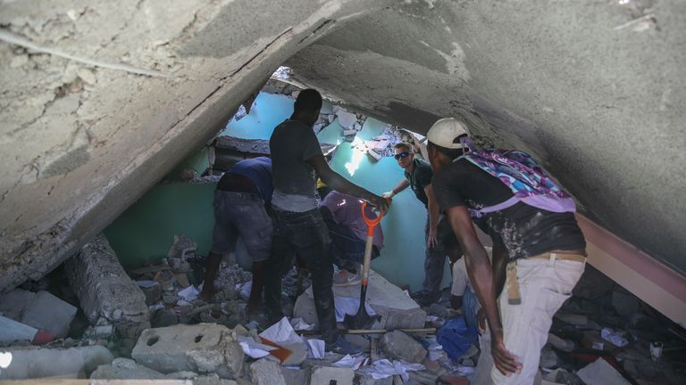 Rescue workers search for survivors in a destroyed home in Les Cayes