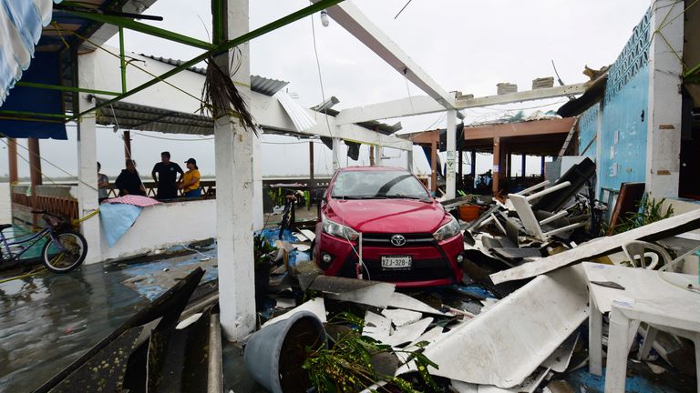 A car stands parked amidst the debris of restaurants that were destroyed after Hurricane Grace slammed into the coast with torrential rains, in Costa Esmeralda, near Tecolutla, Mexico August 21, 2021. REUTERS/Oscar Martinez