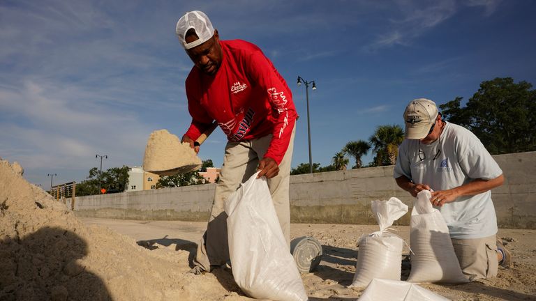 Gregory Moore, left, helps a local residents fill sand bags as they prepare for the expectd arrival of Hurricane Ida Saturday, Aug. 28, 2021, in Gulfport, Miss. (AP Photo/Steve Helber)