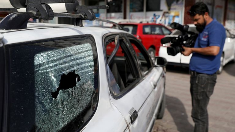 Des journalistes afghans filment le véhicule dans lequel le directeur du Centre d'information médiatique du gouvernement afghan, Dawa Khan Menapal, a été abattu à Kaboul.  Photo : AP