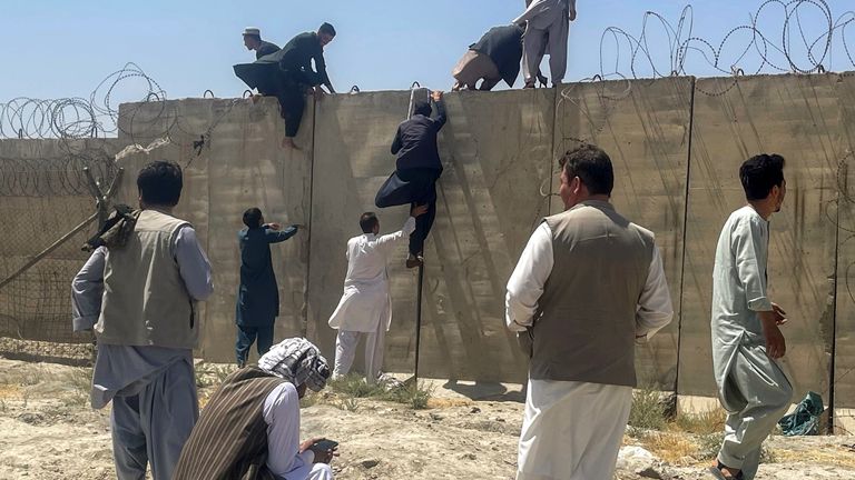 People attempt to leap a wall into Kabul airport