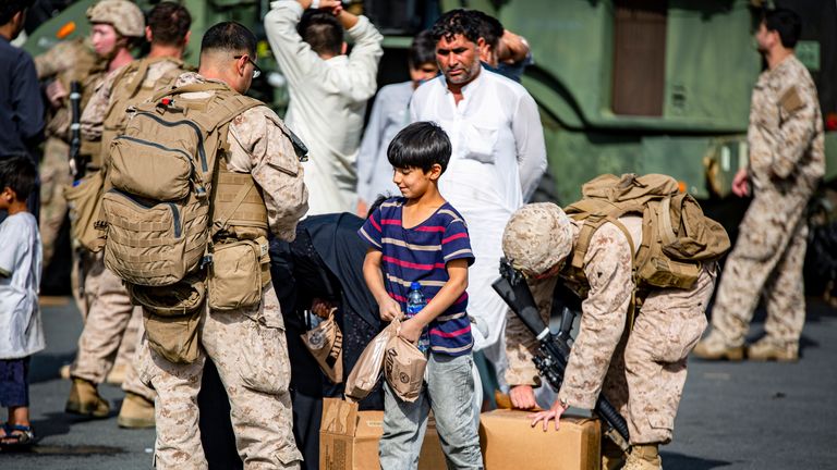 US marines pass out food to evacuees at Hamid Karzai International Airport. Pic: AP