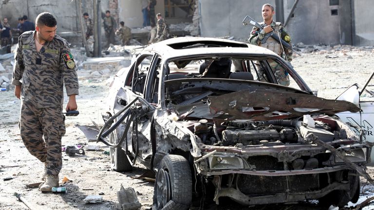 A member of Afghan security forces looks at a damaged car at the site of yesterday&#39;s night-time car bomb blast in Kabul. Pic: Reuters