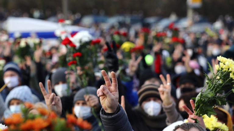 People flash the victory sign as they gather outside a church during a memorial service for Roman Bondarenko, an anti-government protester who died in hospital following what witnesses said was a severe beating by security forces, in Minsk, Belarus November 20, 2020. BelaPAN via REUTERS ATTENTION EDITORS - THIS IMAGE WAS PROVIDED BY A THIRD PARTY. MANDATORY CREDIT.