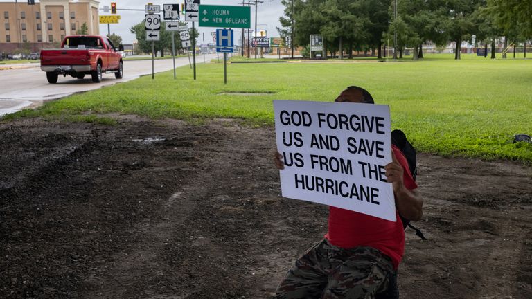 A man holds a placard hours before the arrival of Hurricane Ida, in Morgan City, Louisiana (Pic: AP)