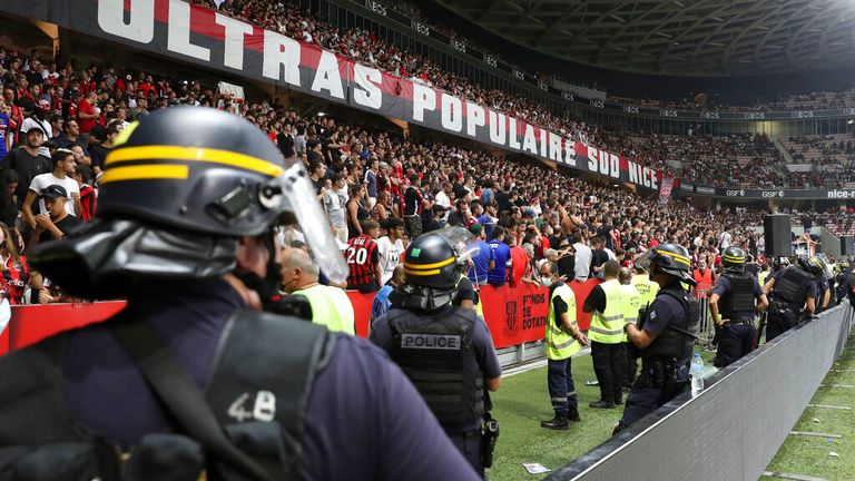 A heavy police presence keeps watch on the Nice fans following the pitch invasion