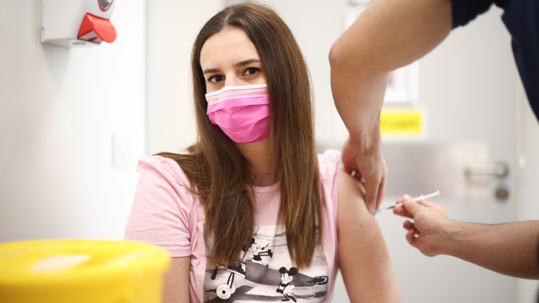 A person receives a dose of the Pfizer BioNTech vaccine at the Central Middlesex Hospital in London, Britain, August 1, 2021. REUTERS/Henry Nicholls