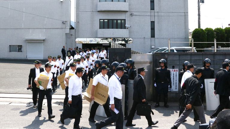 Police leave the building of Kudo-kai following a raid in 2014
