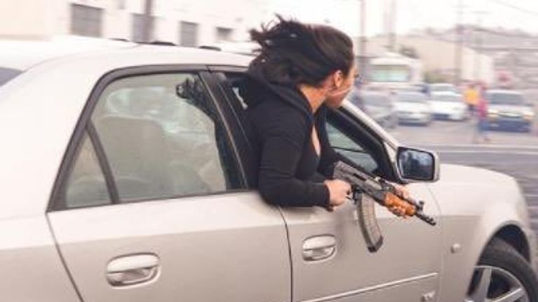 The woman was holding the automatic rifle while leaning out of the Cadillac's window. Pic: San Francisco Police/@SFTrafficSafety