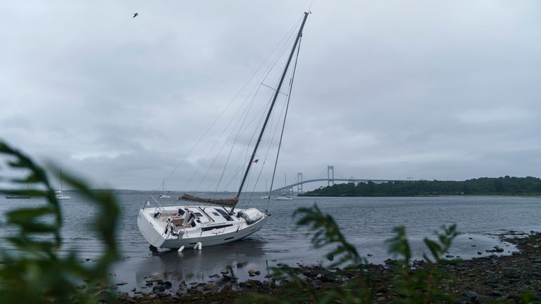 A sailboat sits washed up on shore after becoming loose from its mooring when Storm Henri passed through Jamestown. Pic: AP