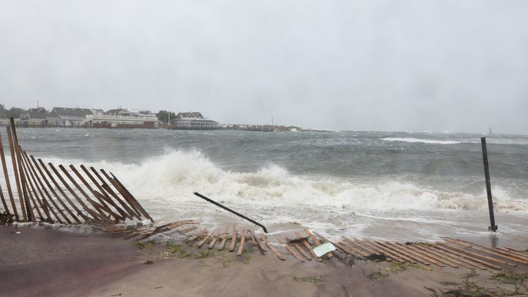 Waves crash onto a fallen fence during Tropical Storm Henri in Montauk, New York