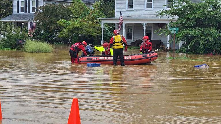 Emergency personnel and first responders work to help residents from their flooded homes. Pic: AP