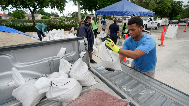 City workers load sandbags at a drive-thru sandbag distribution event for residents ahead of the arrival of rains associated with tropical depression Fred in Miami. Pic: AP