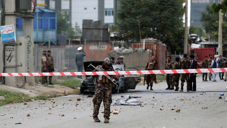 Afghan security personnel inspect a damaged vehicle which was carrying and shooting rockets, in Kabul, Afghanistan, Tuesday, July 20, 2021. 