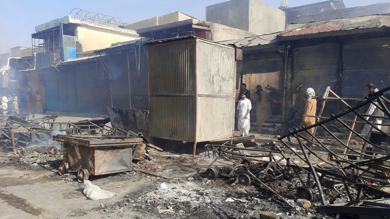 Afghans inspect damaged shops after fighting between Taliban and Afghan security forces in Kunduz city