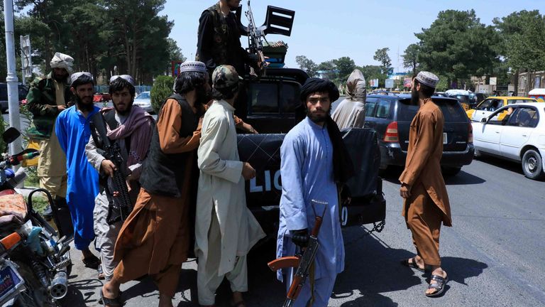 Taliban forces patrol a street in Herat on 14 August