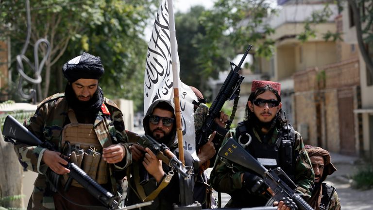 FILE - In this Aug. 19, 2021 file photo, Taliban fighters display their flag on patrol in Kabul, Afghanistan. Twin tragedies on opposite sides of the world are piling misery on people that have seen far more than their share. In Afghanistan, a group of gunmen known for sadistic tyranny rocketed back into power after 20 years as Western and Afghan leaders walked away with a sad shrug. (AP Photo/Rahmat Gul, File)