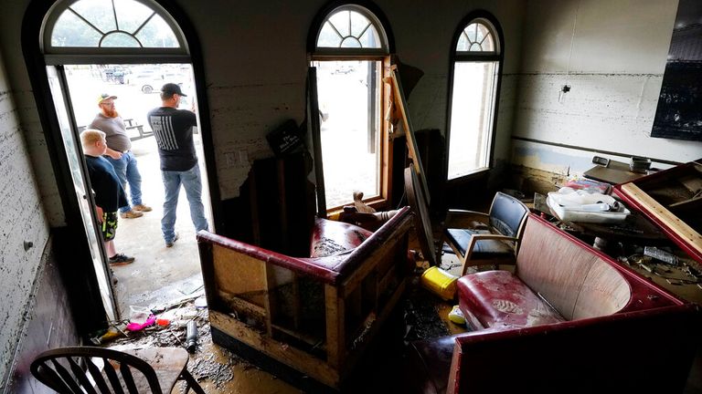 Kansas Klein, standing at right in the doorway, talks outside of his destroyed Bella Blak Pizzeria restaurant