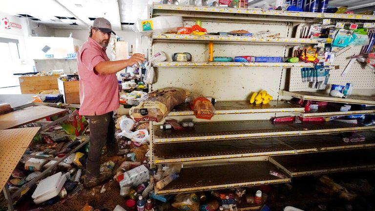 John Curtis, co-owner of Waverly Cash Saver grocery store, walks through his damaged store