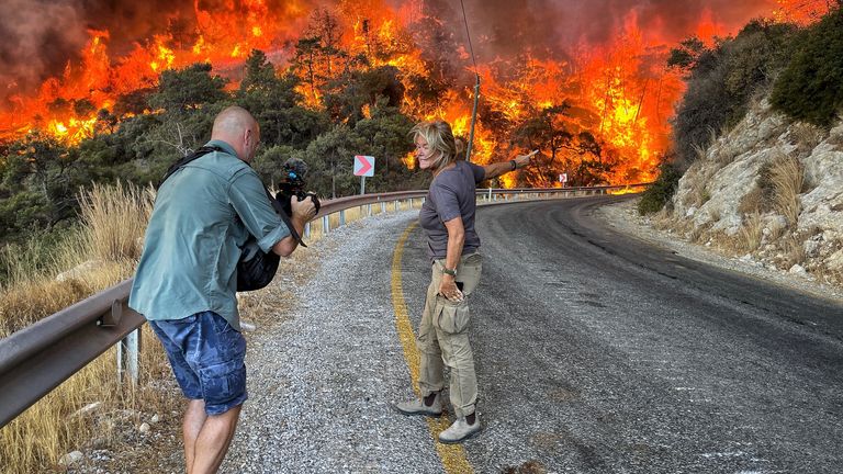 Alex doing a live in front of a wall of flames.