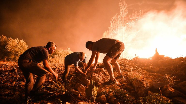 Local villagers try to get a fire under control in Kirli village near the town of Manavgat, in Antalya province, Turkey. Pic: AP