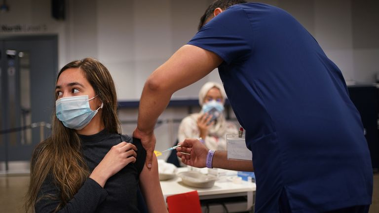 A young woman receives a vaccine at a clinic in London