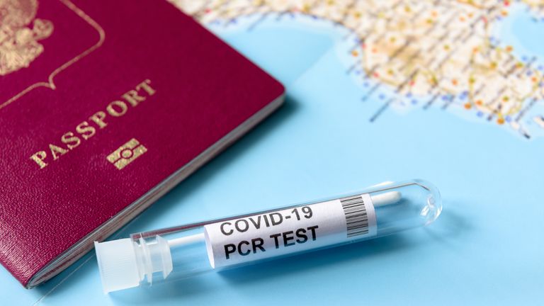 COVID-19, travel and test concept, tube for PCR testing and tourist passport on geographic map. Coronavirus diagnostics in airport due to pandemic. Tourism and business hit by SARS-Cov-2 corona virus