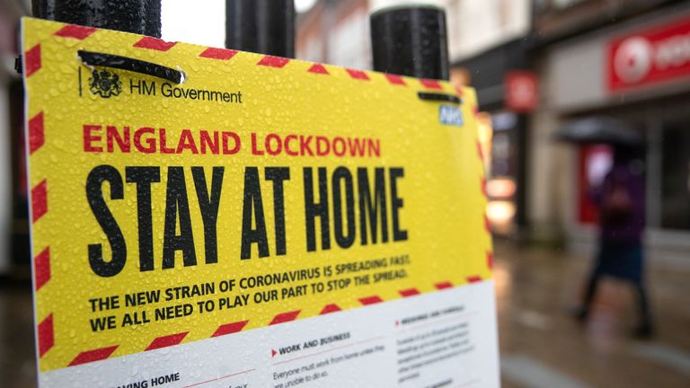 People walk past a Government sign warning people to stay at home on the High street in Winchester, Hampshire, during England's third national lockdown to curb the spread of coronavirus. Picture date: Wednesday January 20, 2021.