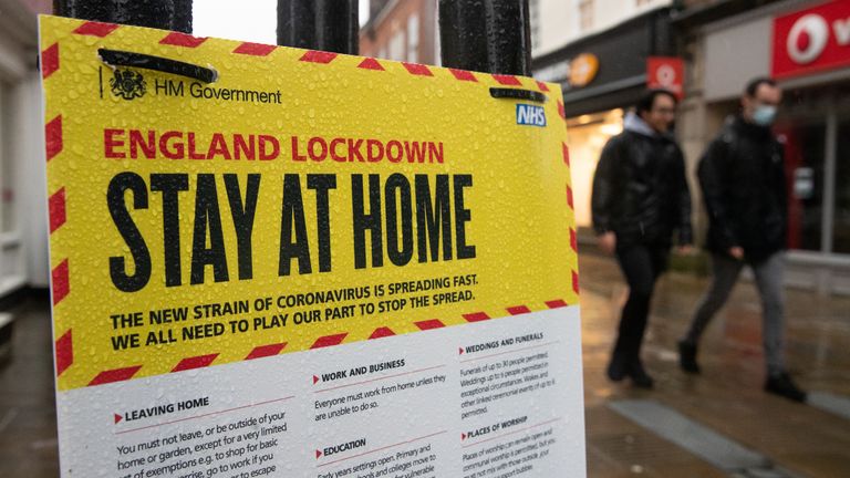 Les gens passent devant un panneau gouvernemental avertissant les gens de rester à la maison dans la rue principale de Winchester, Hampshire, pendant le troisième verrouillage national de l'Angleterre pour freiner la propagation du coronavirus.  Date de la photo : mercredi 20 janvier 2021.