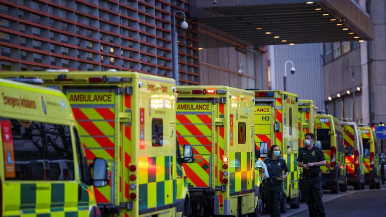NHS workers walk next to a cue of ambulances outside the Royal London Hospital, in London, Britain January 12, 2021. REUTERS/Henry Nicholls