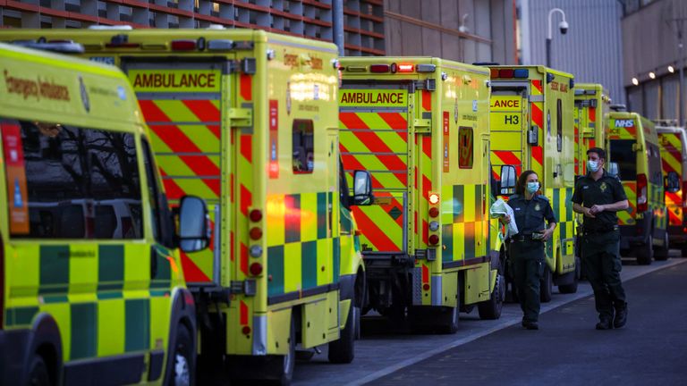 NHS workers walk next to a cue of ambulances outside the Royal London Hospital, in London, Britain January 12, 2021. REUTERS/Henry Nicholls