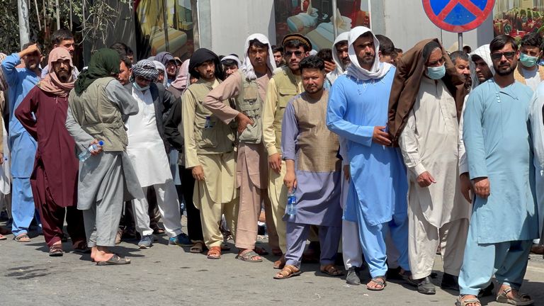 Des Afghans font la queue devant une banque pour retirer leur argent après la prise de contrôle des talibans à Kaboul