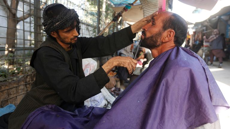 An Afghan man gets his beard trimmed at a street barber shop in Kabul, Afghanistan October 11, 2017. REUTERS/Omar Sobhani
