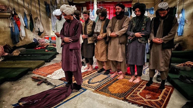 Taliban fighters pray inside the cells