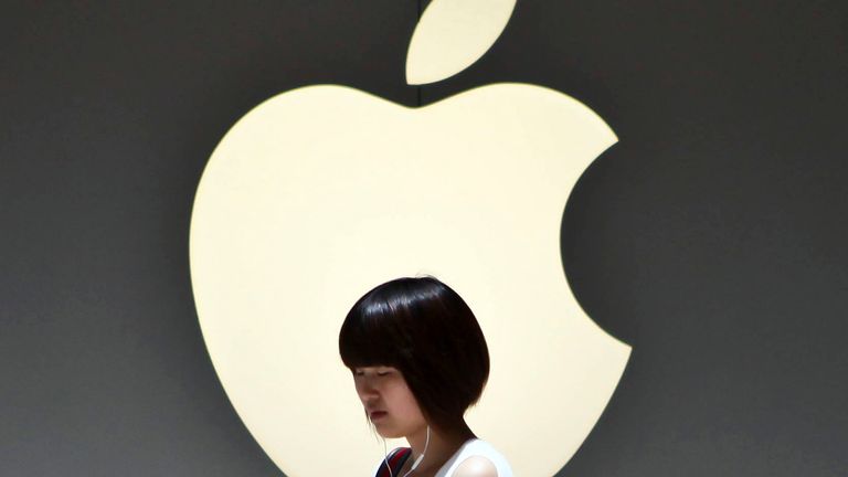 2012 年 7 月 2 日月曜日、中国上海のアップル ストアの外でアップル ロゴの前を通り過ぎる少女主要な中国市場で人気の高いタブレット PC の売上に貢献。  (AP Photo) 中国の外