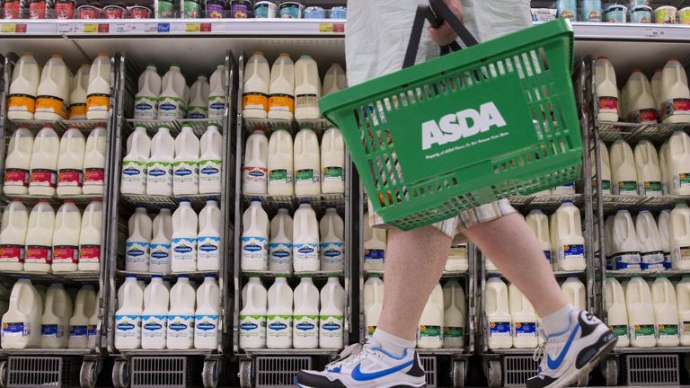 A shopper walks past milk cartons in an aisle of Asda supermarket in London, August 17, 2015.