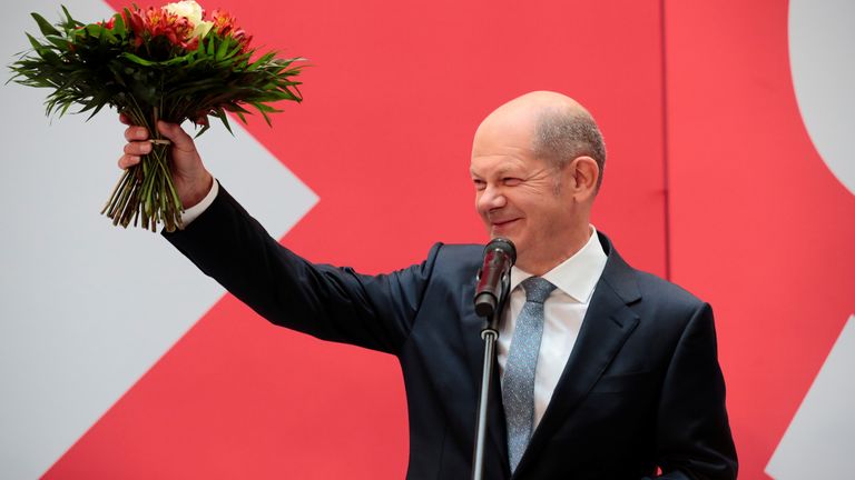 Social Democratic Party (SPD) leader and top candidate for chancellor Olaf Scholz holds a bouquet of flowers at their party leadership meeting, one day after the German general elections, in Berlin, Germany,
