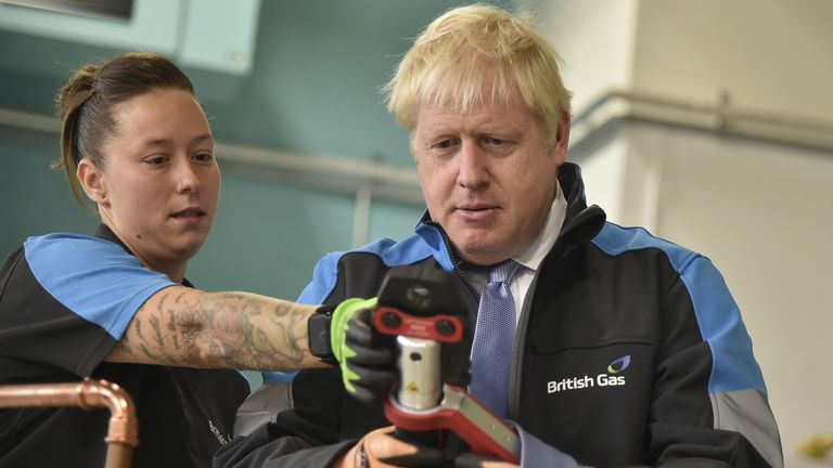 Boris Johnson listens to apprentice Amy Gray during a visit to a British Gas training academy in Leicestershire. Picture date: Monday September 13, 2021.